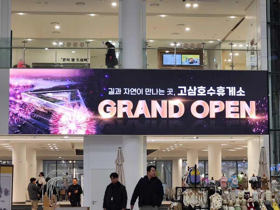 이동식 LED 전광판과 비교한 고정형 설치 후 참고 - 대형 LED 화면이 GRAND OPEN 영상을 송출하는 모습