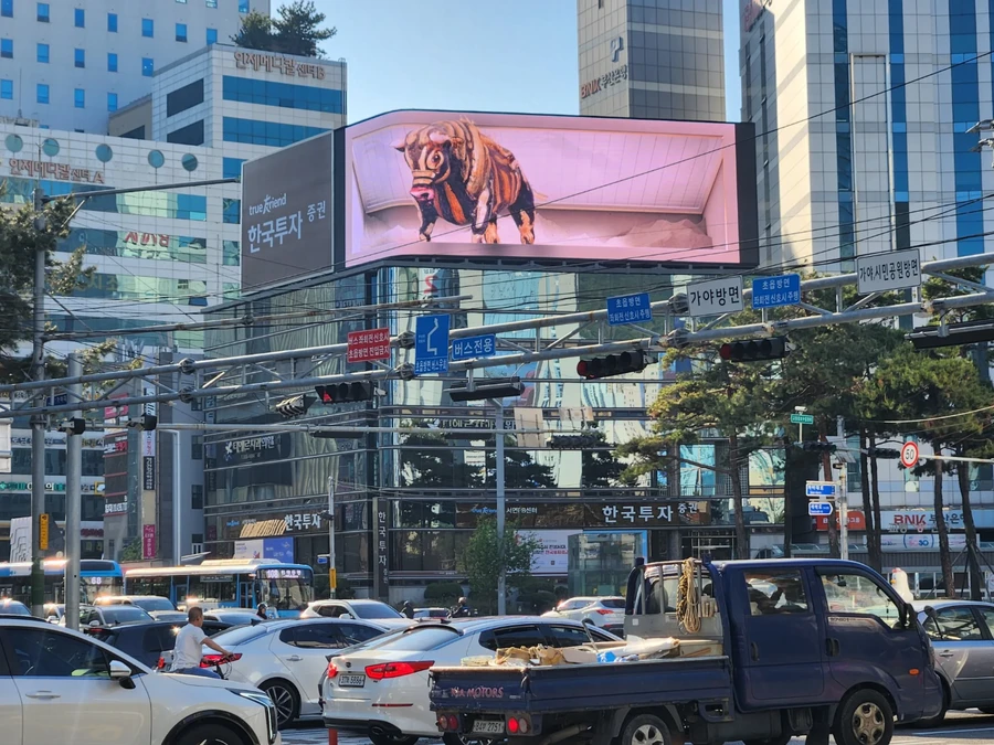 서울 도심 교차로 인근 건물에 설치된 대형 LED 화면과 도로를 지나는 트럭